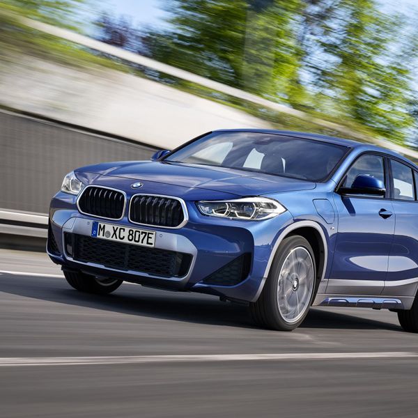 Blue BMW xdrive25e driving front and left side